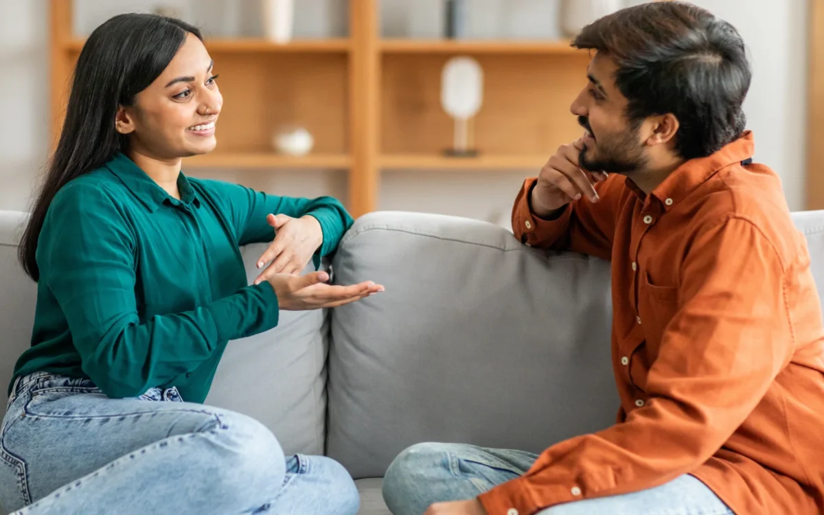 Couple sitting close in quiet, attentive conversation at home, illustrating what do women want in a relationship